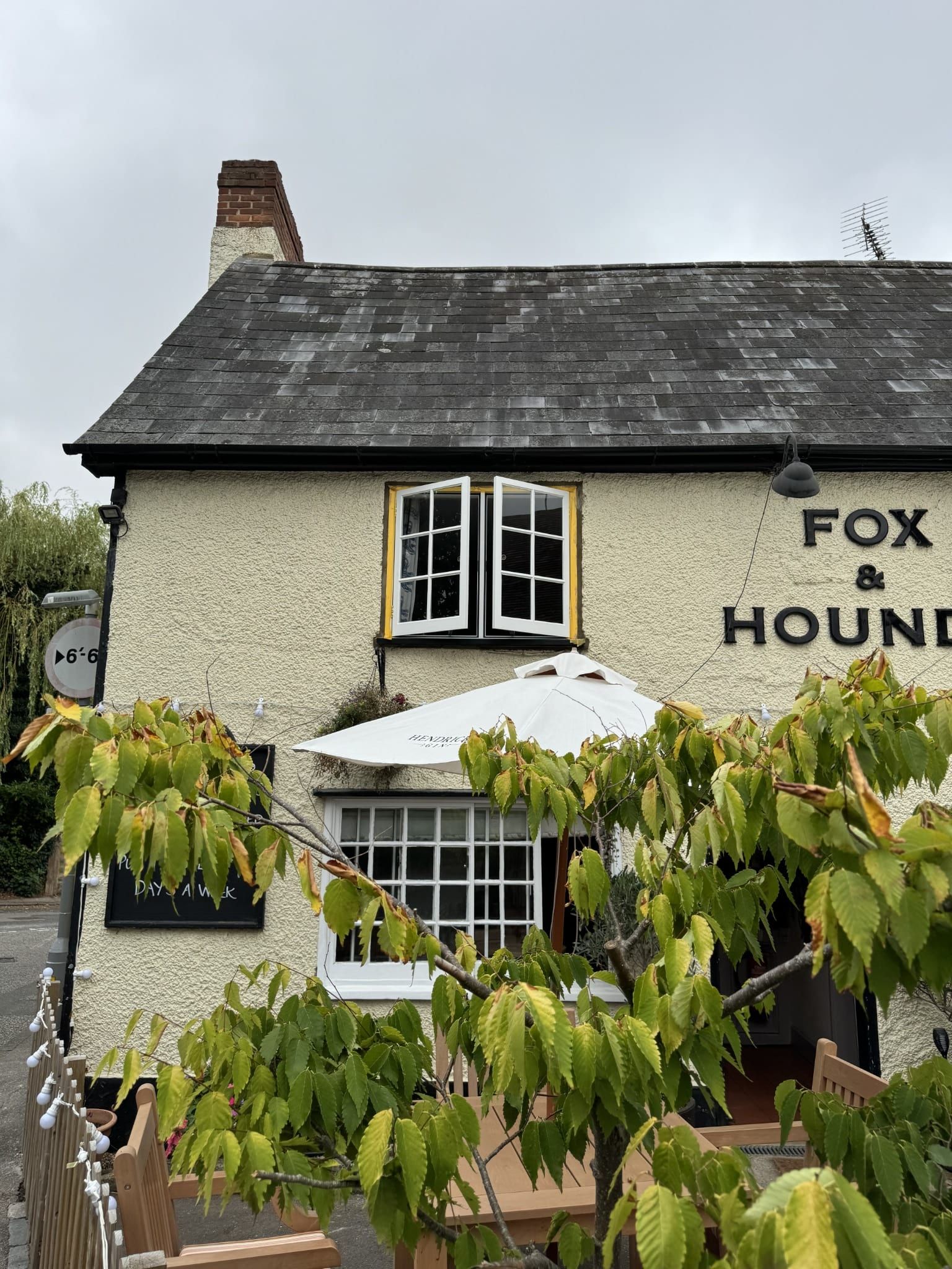 Traditional pub exterior with painted render, timber windows and signage