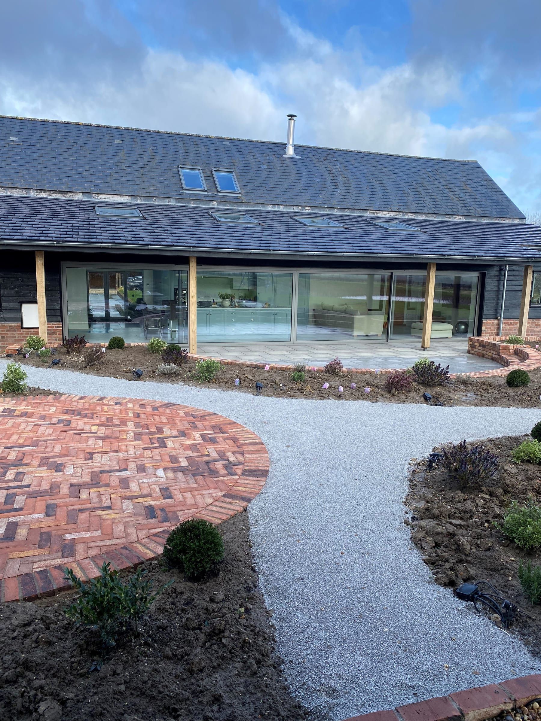 Glazed sliding doors beside a circular brick herringbone patio