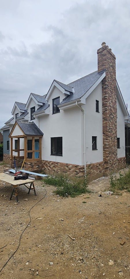 Completed new build side elevation showing brick chimney and dormer windows