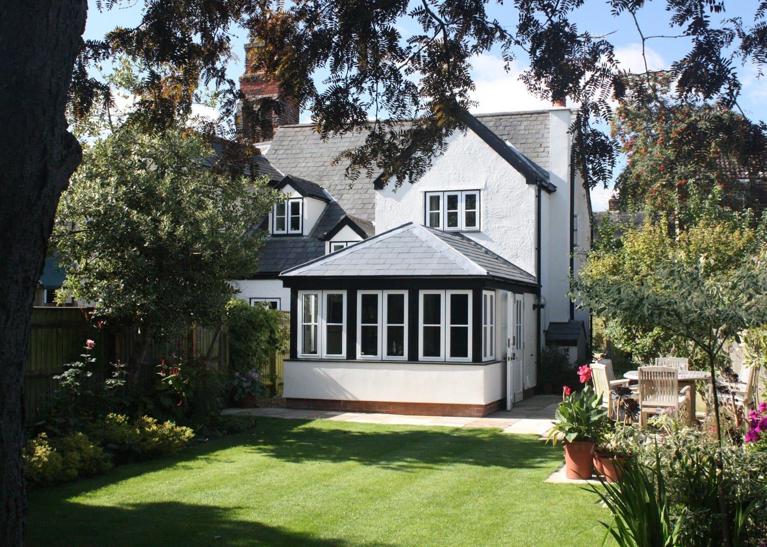 Single-storey hipped-roof garden room extension with black window frames
