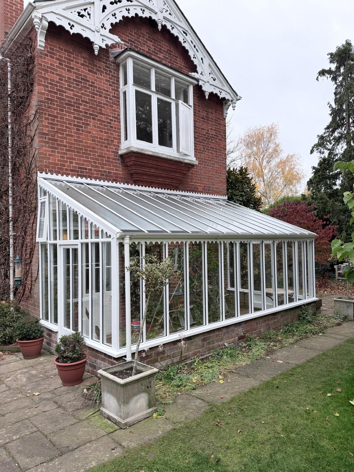 White-framed Victorian-style conservatory extension on red brick house