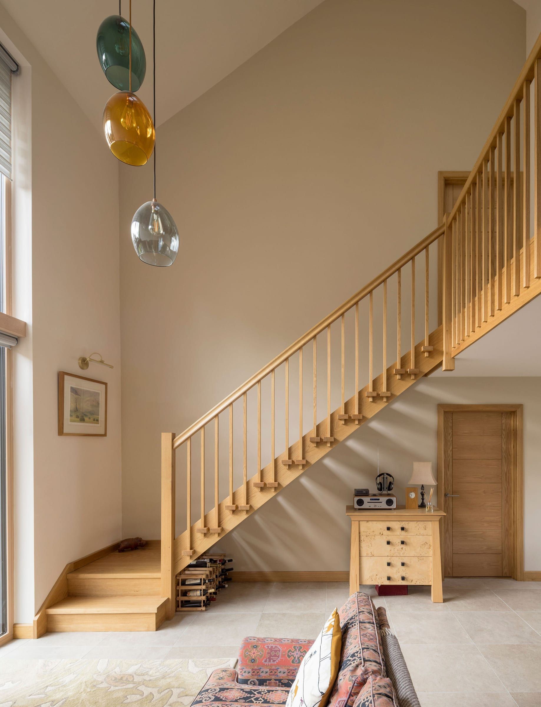 Oak staircase with balustrade in a bright open-plan hallway