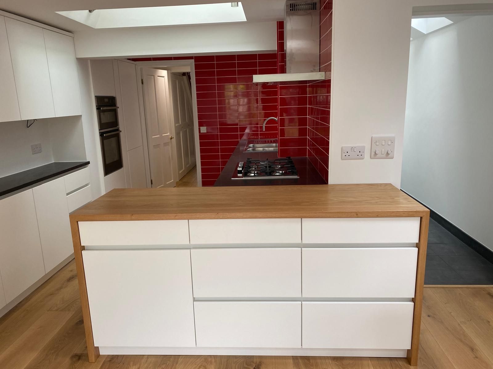 Kitchen renovation with red tiles, oak breakfast bar and built-in ovens