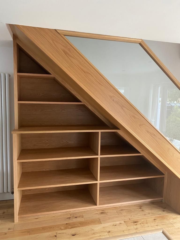 Bespoke oak shelving unit built into under-stairs space