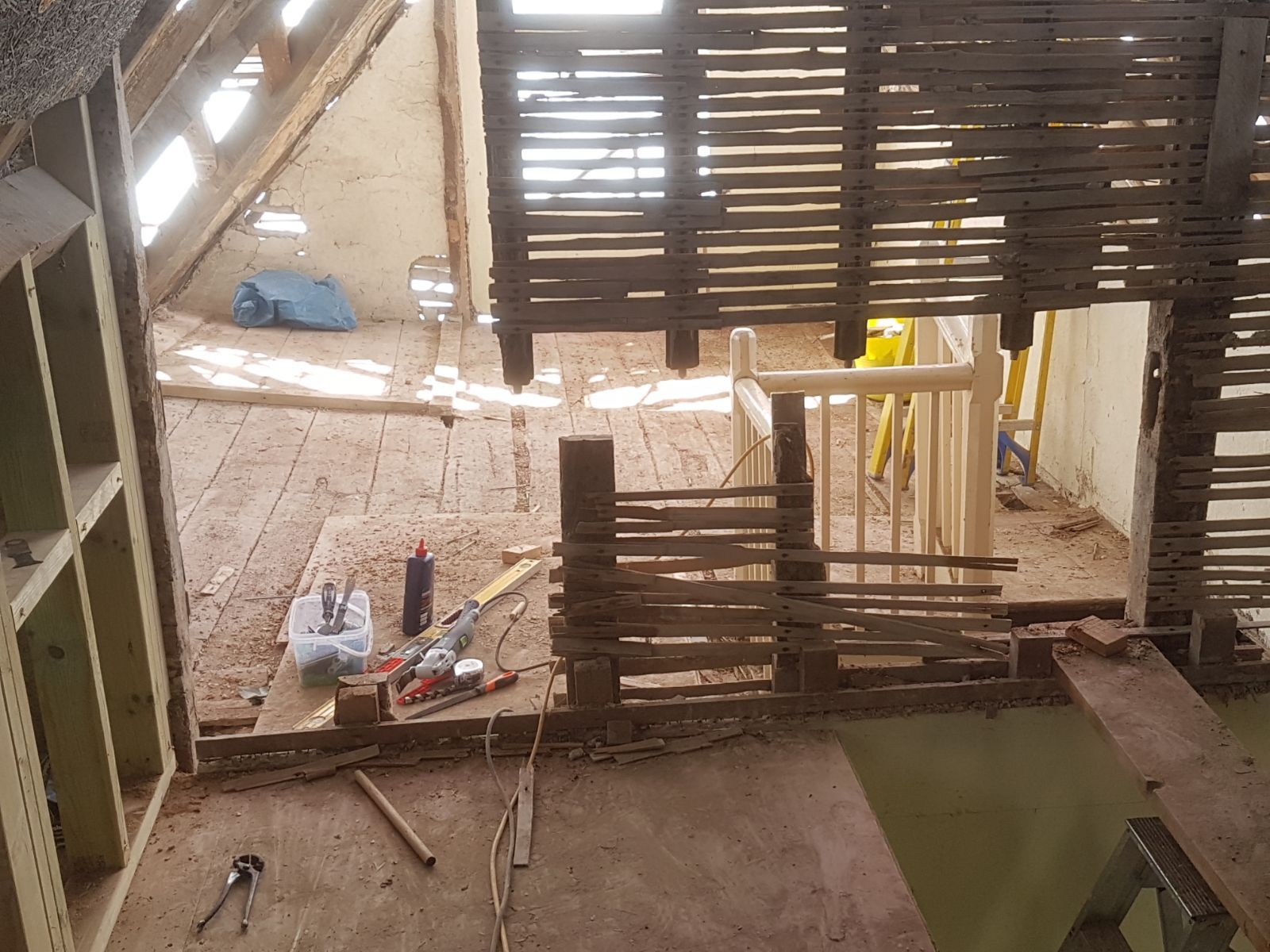 Exposed timber lath partition wall beside original staircase during restoration