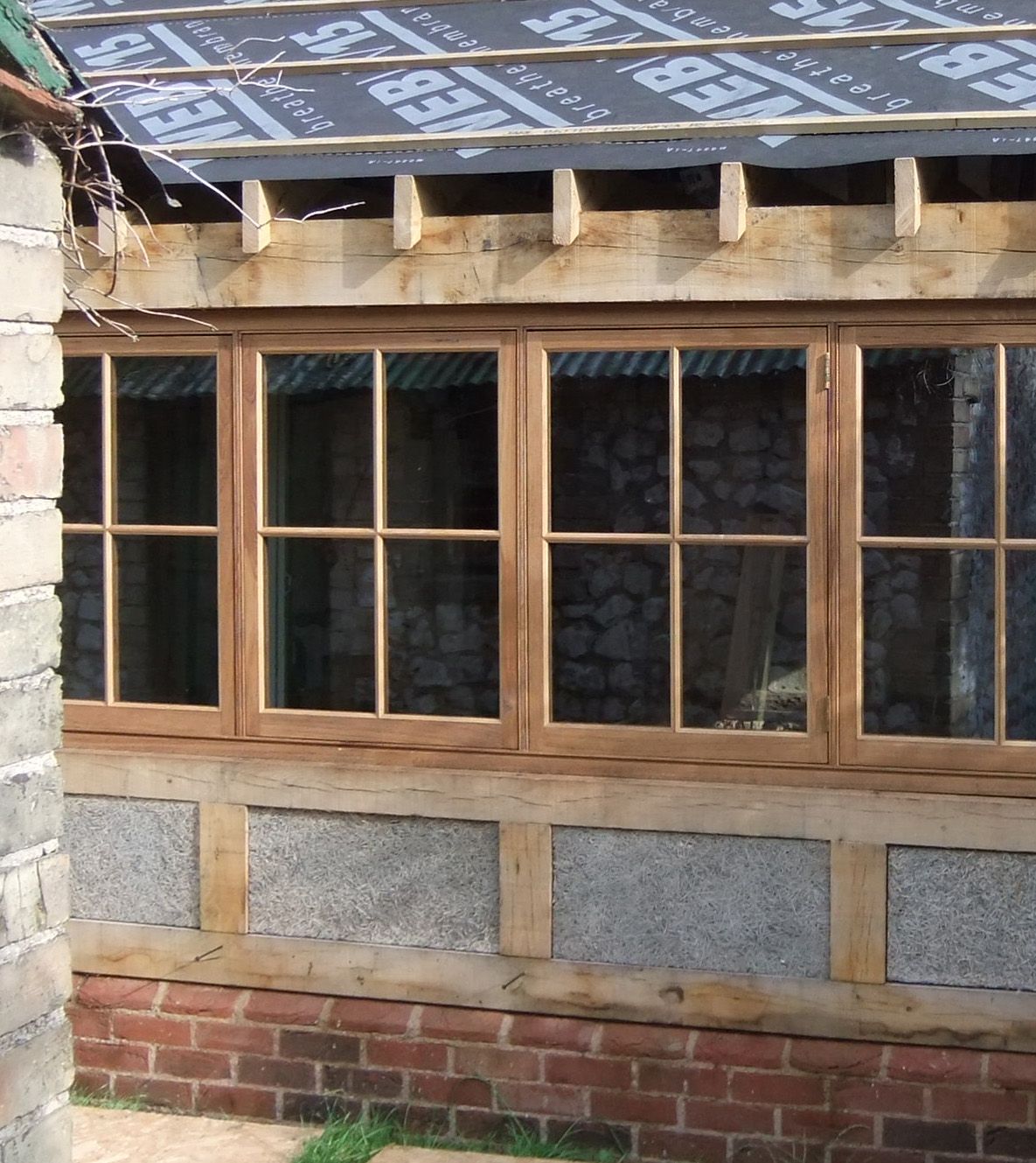 New oak casement windows fitted into timber-framed wall with insulation panels