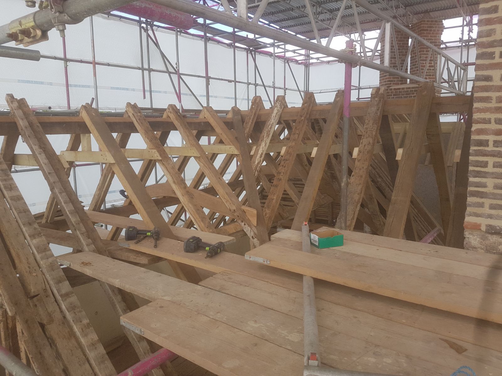 Close-up of traditional oak roof truss joinery with scaffolding