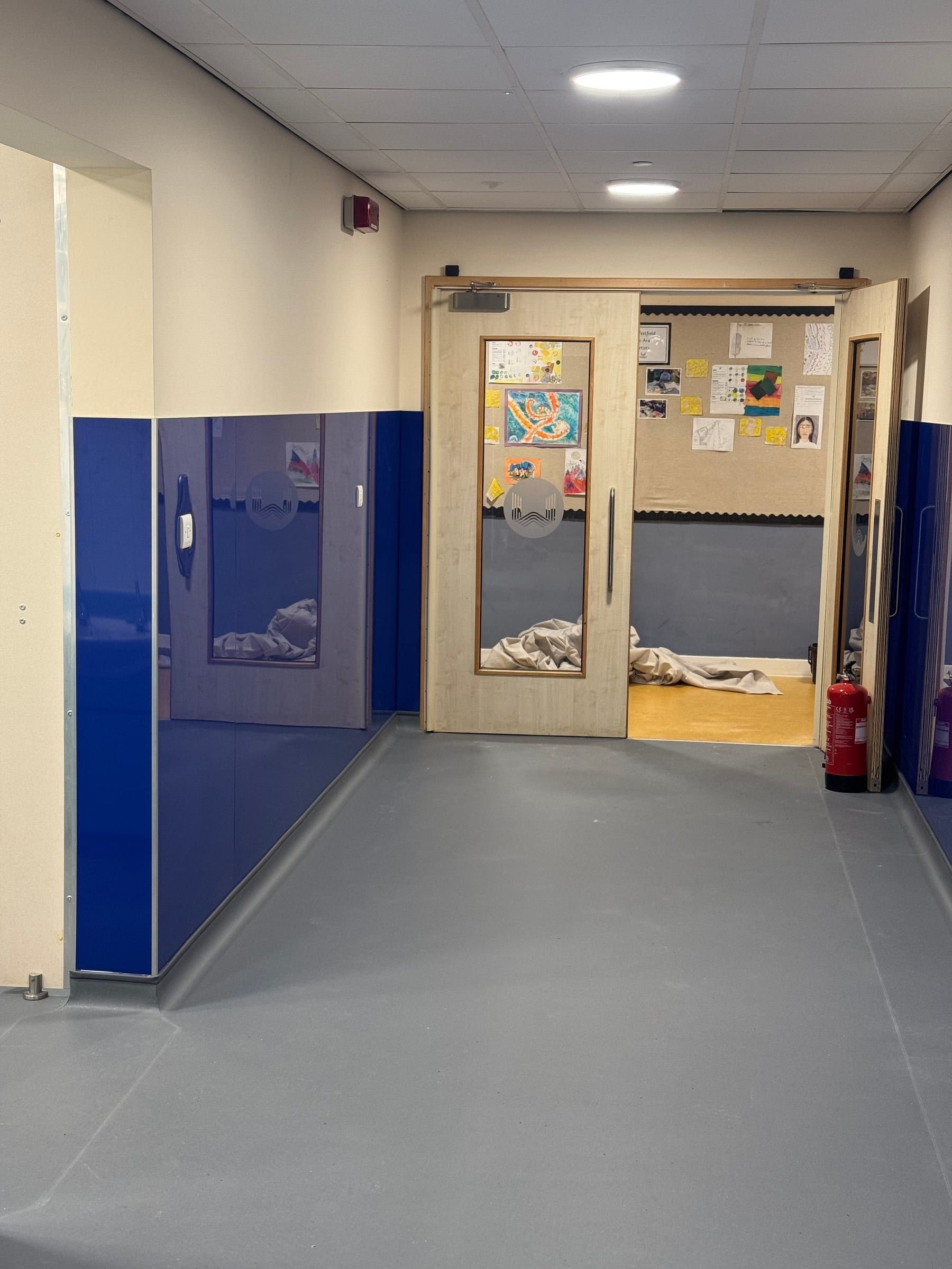 School corridor with new blue wall panelling and glazed classroom doors
